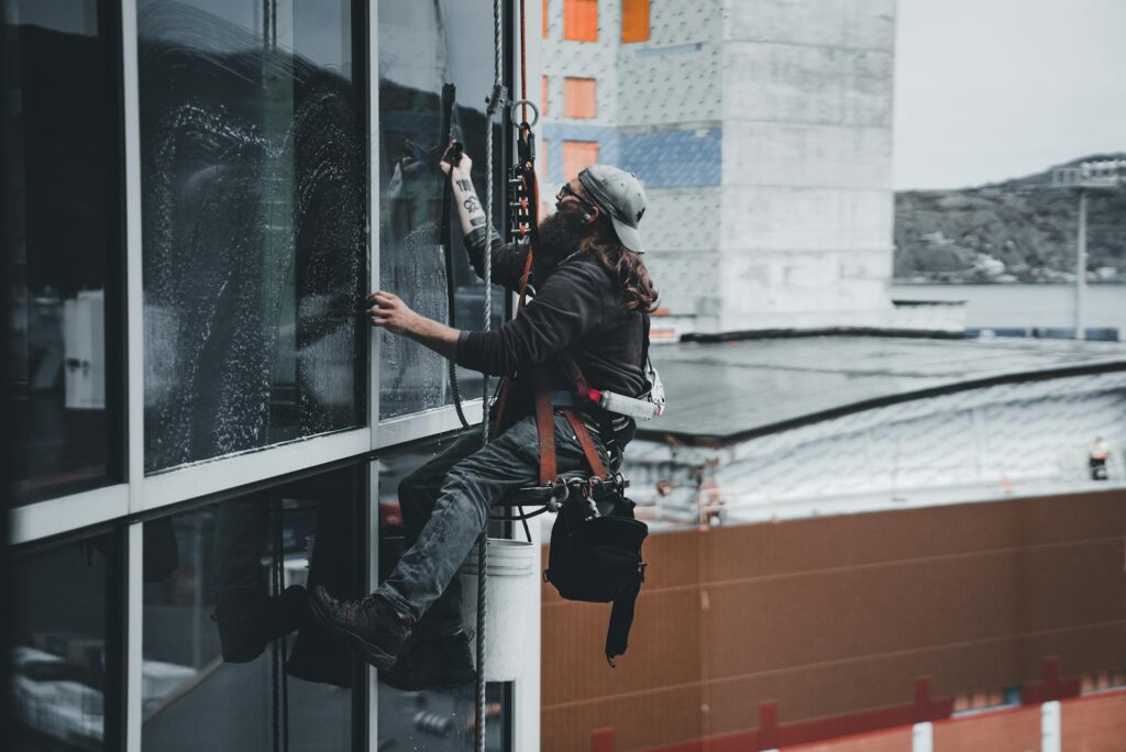 A man cleaning the window of a commercial Building